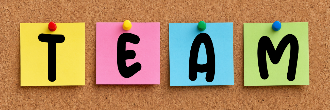 Bunte Post-its mit den Buchstaben T E A M an einer Korkwand befestigt